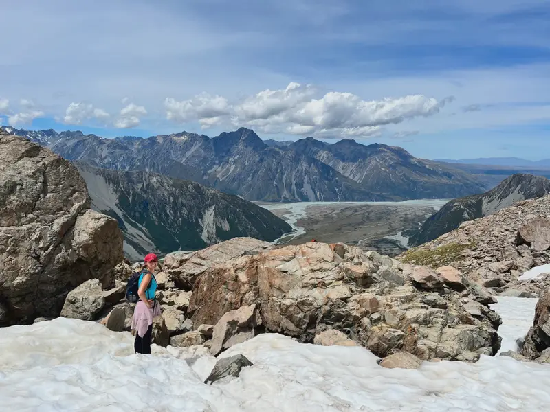 Standing on the rock above a glacier terminus, the ice running back into the range.
