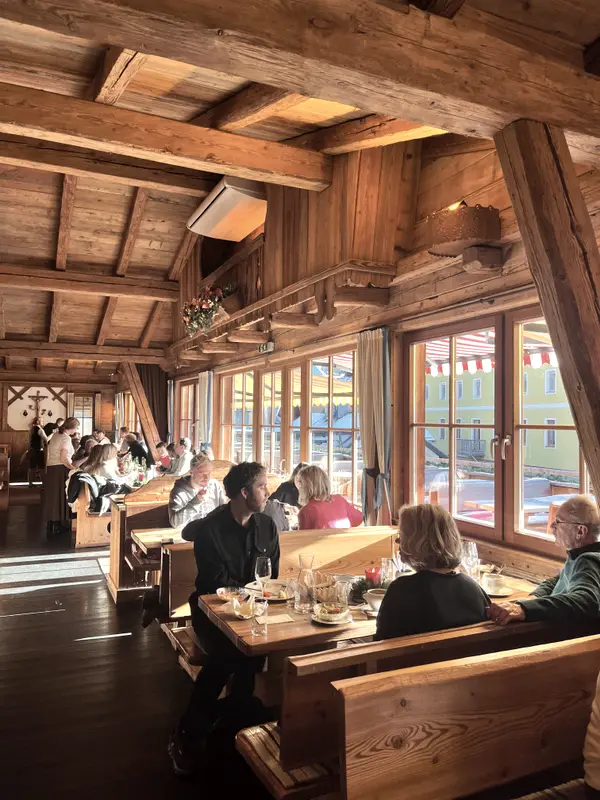 A wood-panelled dining room, tables full and windows onto the snow.