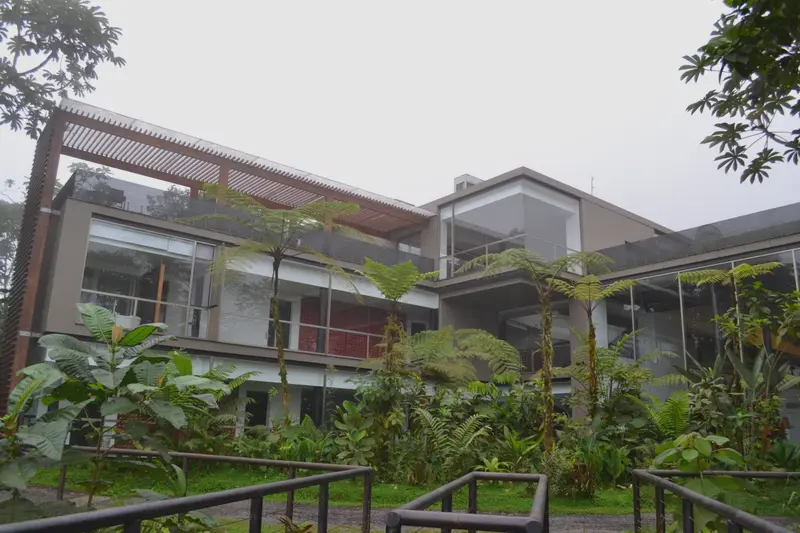 The lodge from the garden path, the building set into a slope of dense cloud forest.