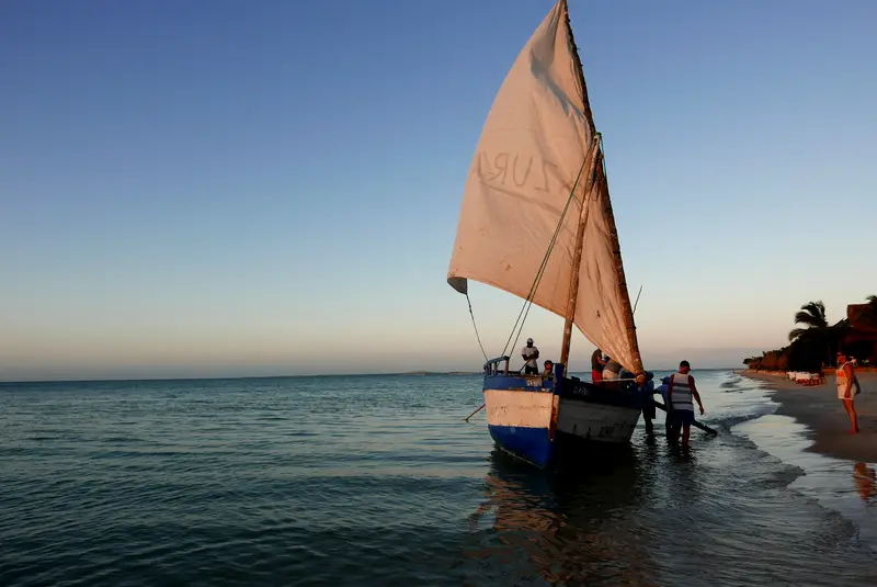 A dhow under sail being walked off the beach in the Bazaruto Archipelago, Mozambique.