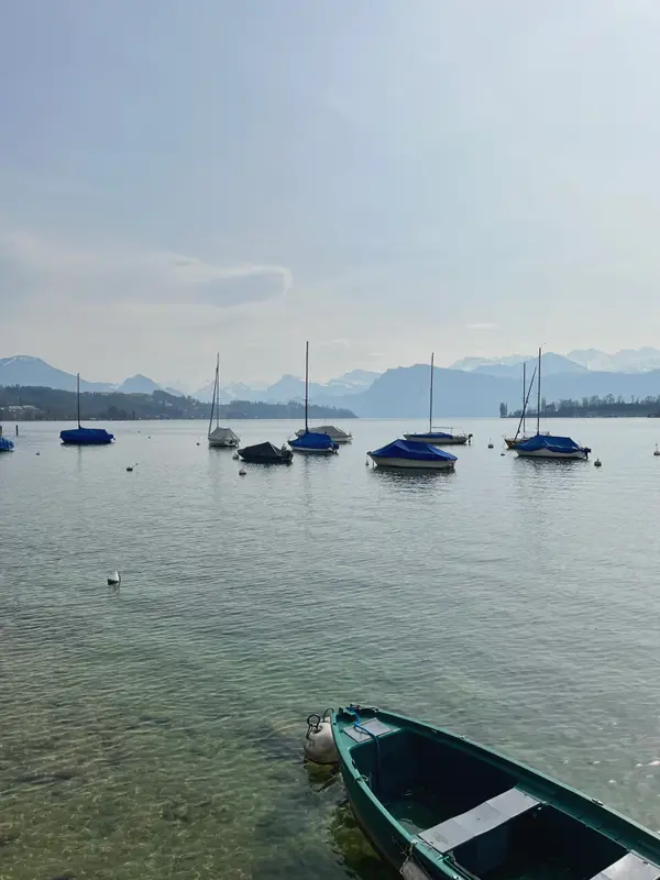Moored boats on the lake at Zurich, flat water and low cloud on the far shore.