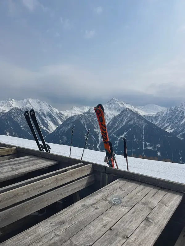 Skis stood on a sun deck, the Dolomites in cloud behind.