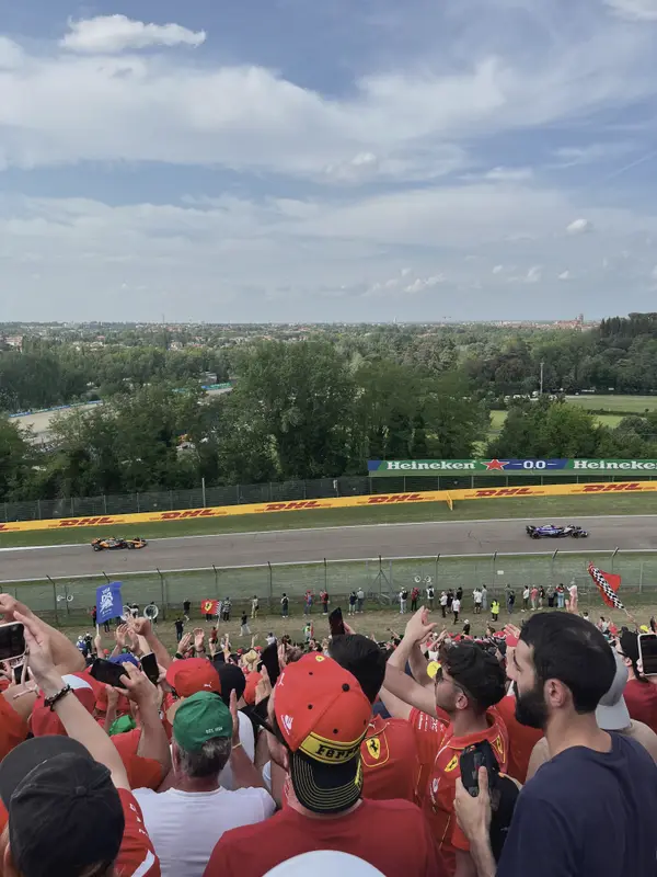The crowd at Imola in Ferrari red, cars coming through the corner below.