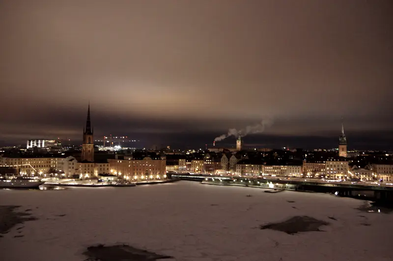 Stockholm at night from across the ice, the old town lit along the waterline.