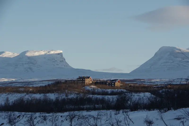 The Lapporten notch above Abisko, the lodge small against the treeline below it.